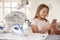 Young girl using distracted by phone while ironing