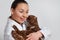 Young girl veterinarian in working clothes with a funny cat in her arms. On light background