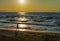 Young girl walking along beach, gold sunset