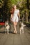 Young girl walking down the street with two dogs.