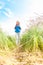 Young girl walking in meadow with backpack on.