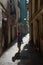 A young girl walking through tight and empty street of the Gothic Quarter of Barcelona, Catalonia.
