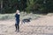 A young girl walks her husky dog on the beach.