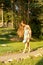 young girl walks the park barefoot in the bright sun in a summer sarafan