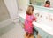 Young girl washing hands in bathroom