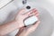 Young girl washing hands with a soap. Hygiene