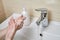 A young girl is washing hands with soap and water. Viral Disease Prevention. Closeup, selective focus