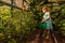 Young girl water with the watering can in the greenhouse