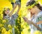 Young girl wearing Romanian traditional blouse taking selfie in canola field