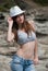 Young girl wearing shorts and crop top and hat posing outside