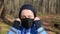 Young girl wears a black mask before jogging in the forest