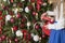 A young girl wears a tree. Girl in formal. The process of preparation for the celebration of New Year and Christmas