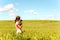 Young girl in wheat field holding dog contemplating the nature