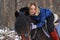 A young girl with white hair is riding a horse. The girl hugs her favorite horse. Winter cloudy day. Close-up