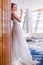 young girl in white wedding dress is standing wood wall in hotel lobby. lifestyle concept, vertycal photo