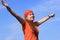 Young girl woman with long wavy brown hair, orange T-shirt tee-shirt and bandanna scarf is happy in summer sunny day and sky