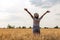 Young  girl woman traveler with backpack in hat stands in field at sunset and looks away, concept of freedom of choice, future, co