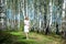 Young girl in the woods in a white dress. A girl walks in the forest