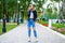 Young girl in a woolen sweater and torn jeans posing in an autumn park