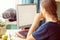 Young Girl working or studying online in front of computer monitor in home cozy atmosphere. Blurred shot, soft focus