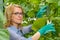 A young girl works in a greenhouse. Industrial cultivation of vegetables.