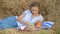 Young girl in a wreath resting in straw haystack