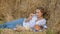 Young girl in a wreath resting in straw haystack