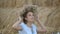 Young girl in a wreath resting in straw haystack