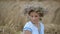 Young girl in a wreath resting in straw haystack