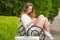 Young girl writes a message on phone, on a park bench