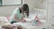 young girl writing in a notepad while home schooling in her bedroom during the coronavirus pandemic