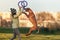 Young girl in yellow coat playing with the jumping dog ridgeback and pullers in autumn time