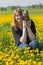 Young girl with yorkshire terrier in the dandelion meadow