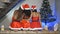 Young girls European, Asian and African in red New Year`s clothes and a hat sit on a bench at a Christmas tree holding in each