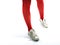 Young girls legs in red tights and old sneakers