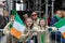 young girls at a parade wearing irish flags and glasses in front of a metal fence