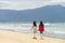 Young girls passing by on China Beach of Danang