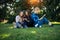 Young girls relax in the park on green grass. Students spend their free time in nature, read books, communicate in social networks