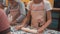 Young girls rolling dough with wooden roller on cooking class in culinary school. School girl preparing dough for baking