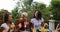 Young Girls Sitting At Table Chatting While Men Group Cooking Barbecue Friends Gathering On Summer Terrace Talking