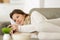 Young glad woman lying on cozy sofa with mobile phone