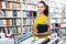 Young glad woman taking books in hard cover