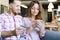 Young gladden woman and man using smartphone and debit card at cafe.