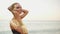 Young glamorous beautiful model posing on a beach in a swimsuit. Girl in black swimsuit with golden skin and