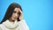 Young good business girl standing on a blue background. During this surprised, she puts her hand on his head