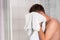 Young good-looking guy dries his face with a clean towel