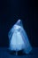 Young graceful balerina in image of ghost bride in art performance isolated on dark background in neon light.