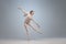 Young and graceful ballet dancer, ballerina dancing in image of angel with wings  on gray studio background. Art