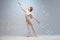 Young and graceful ballet dancer, ballerina dancing  on white gray studio background. Art, motion, action