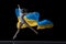 Young graceful classic ballerina dancing with cloth painted in blue and yellow colors of Ukraine flag on dark studio